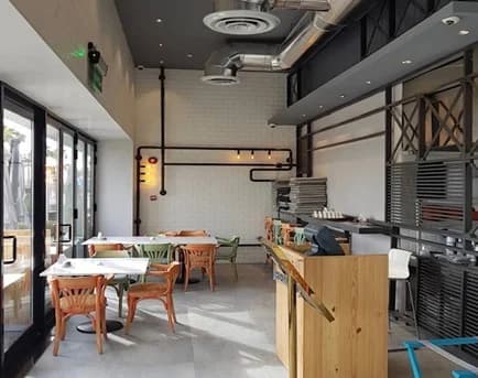 Dining furniture, timber finishes and an exposed-services ceiling.