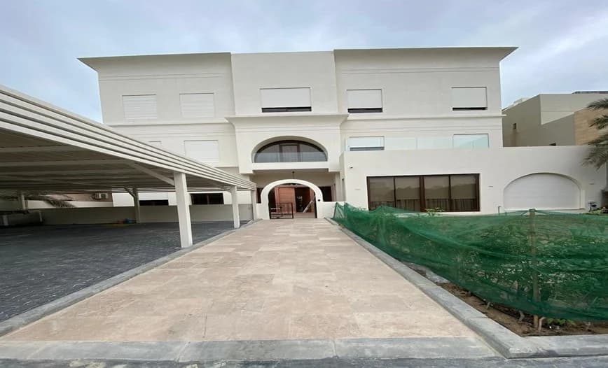 A residential façade with covered parking and a paved approach.