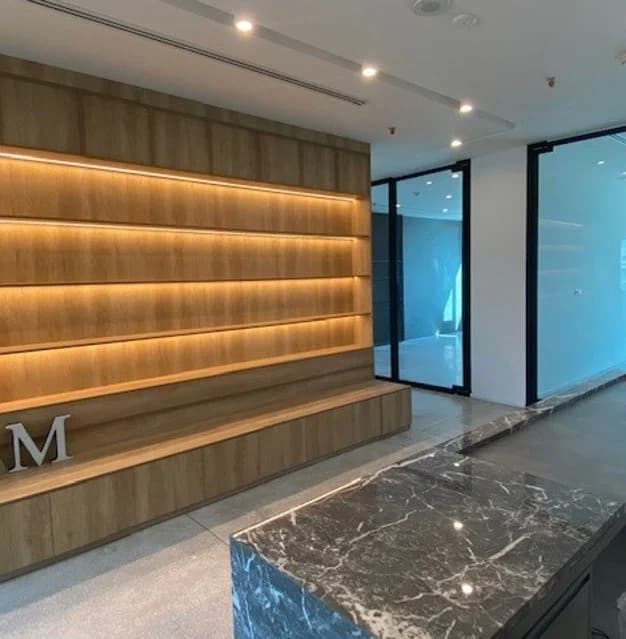 Integrated shelf lighting, timber joinery and polished stone flooring.
