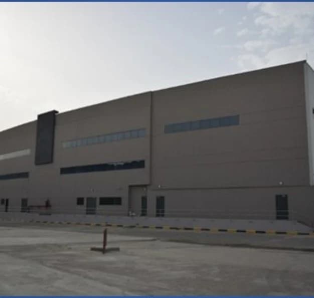 An additional exterior view of the industrial building and its paved surroundings.
