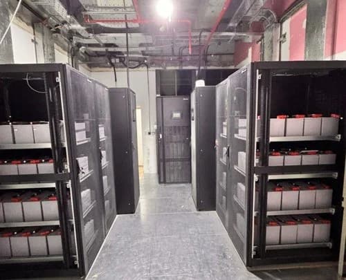 Battery cabinets and overhead services within a technical equipment room.
