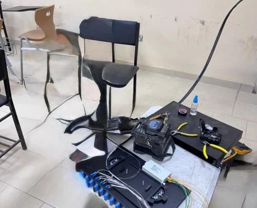 Portable fibre-optic equipment, leads and tools arranged at a field workstation.
